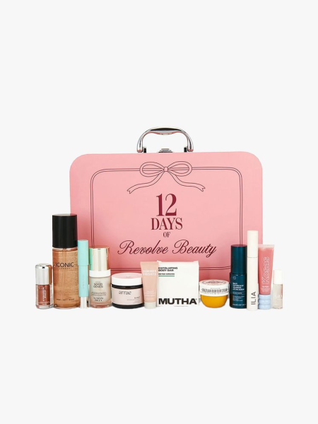Pinkcolored case with silver handle and 25 beauty products in front on light gray background
